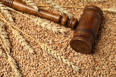 Photo of Wooden gavel and wheat ears on grains, closeup. Agricultural deal