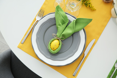 Photo of Festive Easter table setting with colorful egg, top view