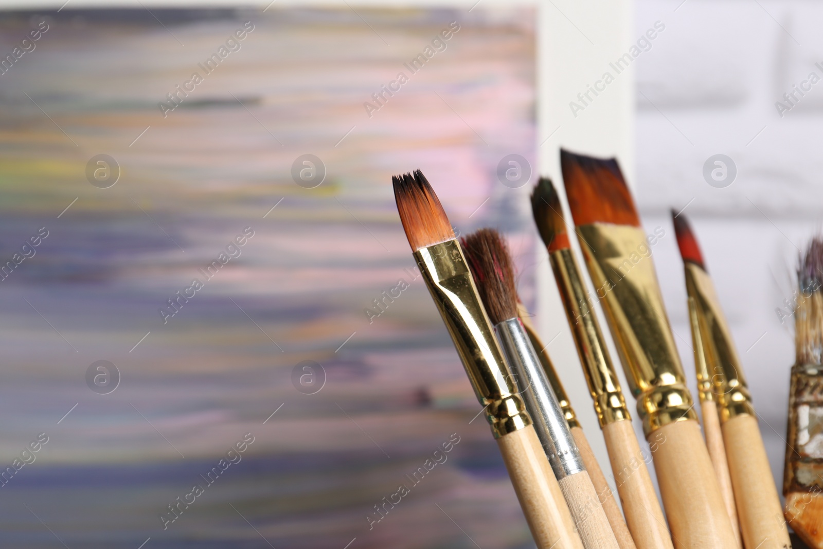 Photo of Closeup view of different brushes on blurred background. Space for text