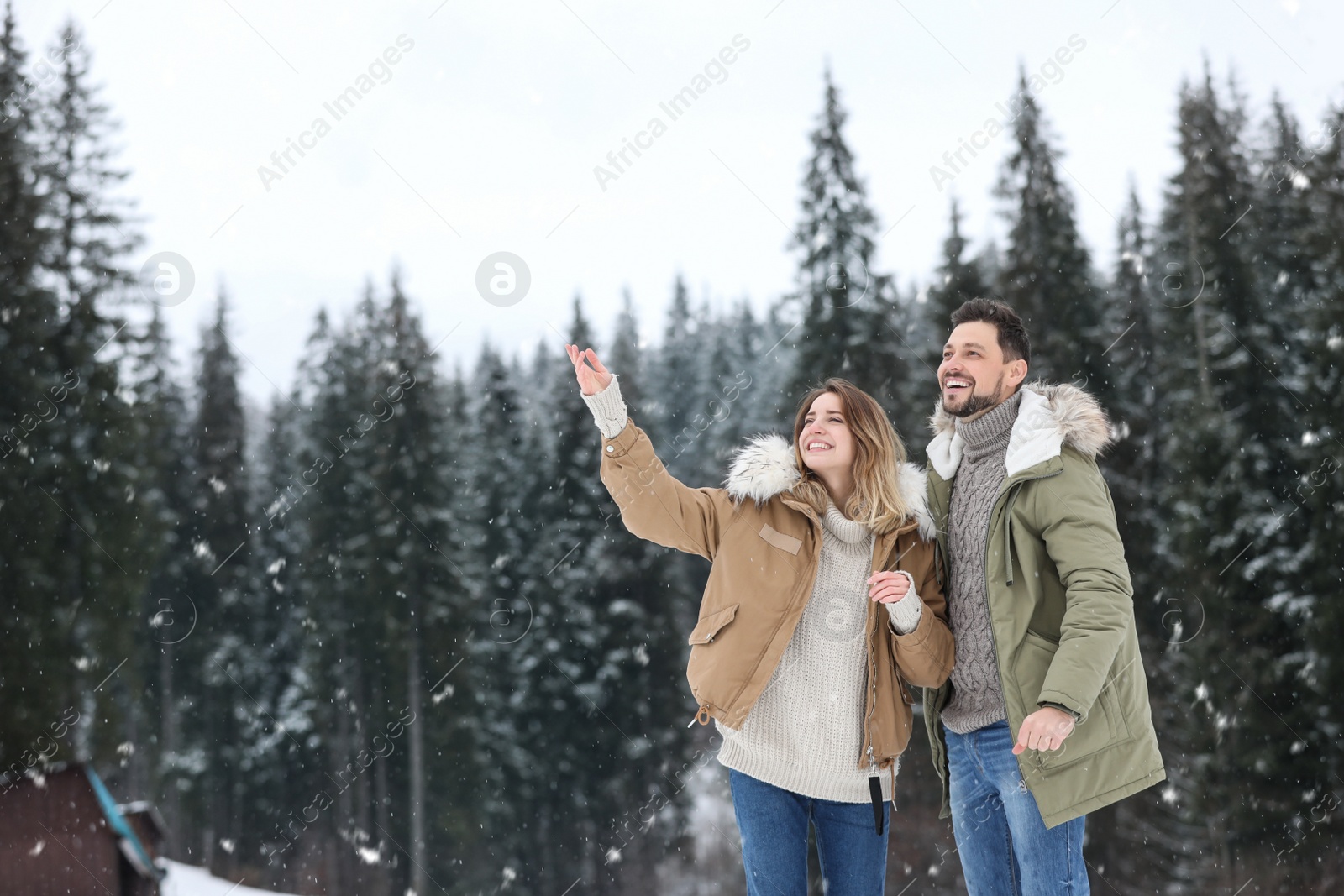 Photo of Couple spending time outdoors on snowy day, space for text. Winter vacation
