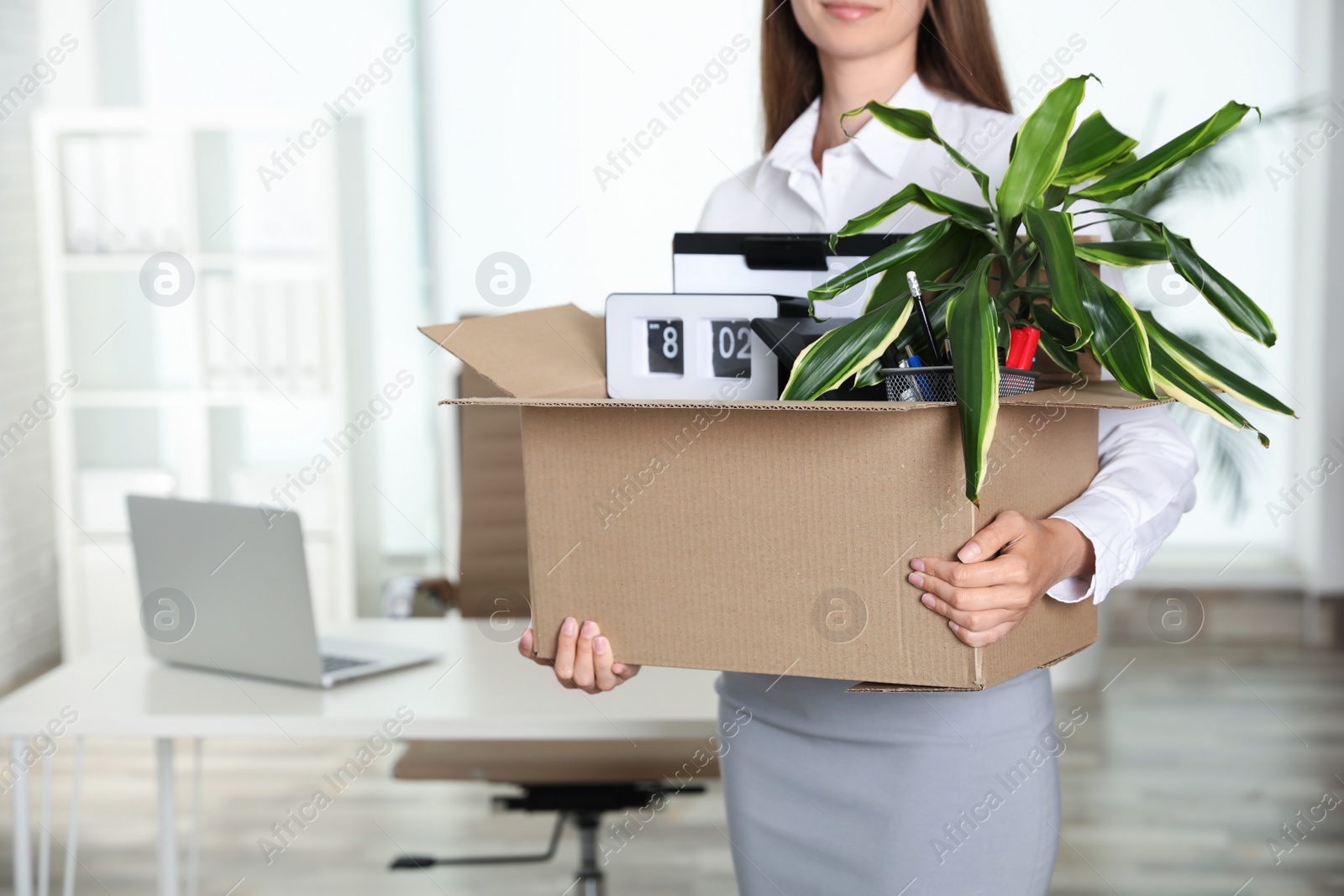 Photo of Young woman holding box with stuff at office, closeup