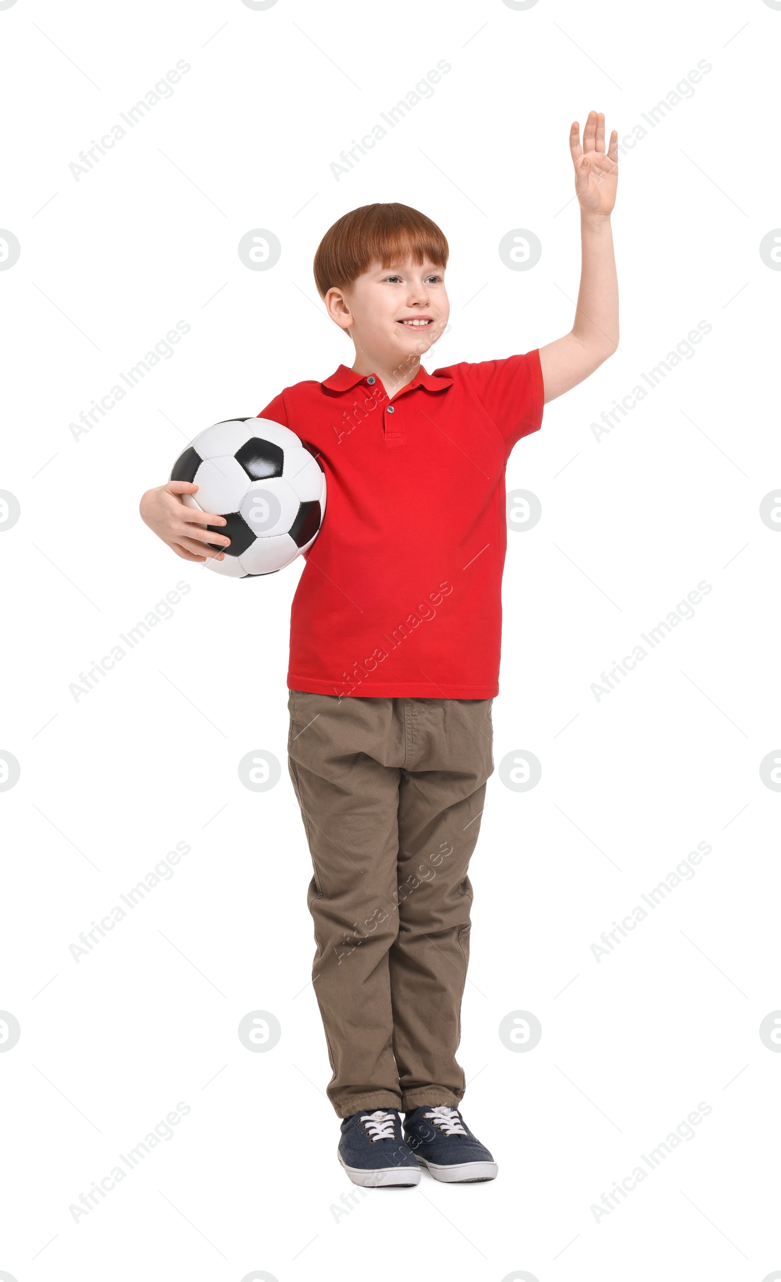 Photo of Little boy with soccer ball waving hand on white background