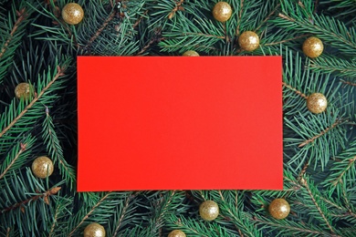 Blank card on Christmas tree branches as background, top view. Space for text