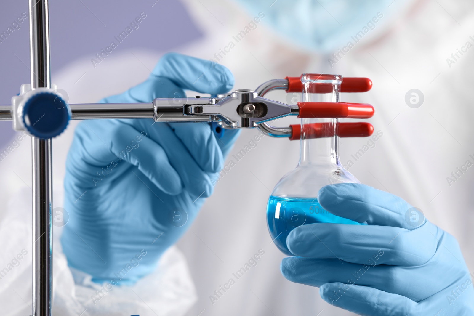 Photo of Scientist fixing flask on stand, closeup view