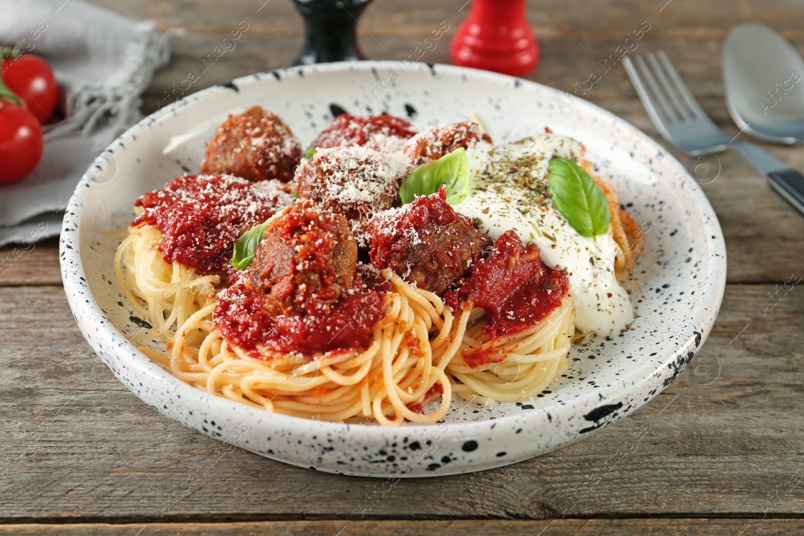 Photo of Delicious pasta with meatballs and tomato sauce on wooden background