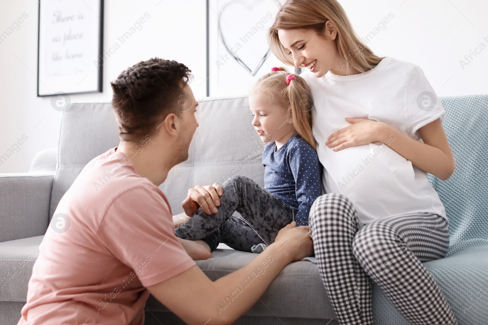 Photo of Young pregnant woman with her family at home