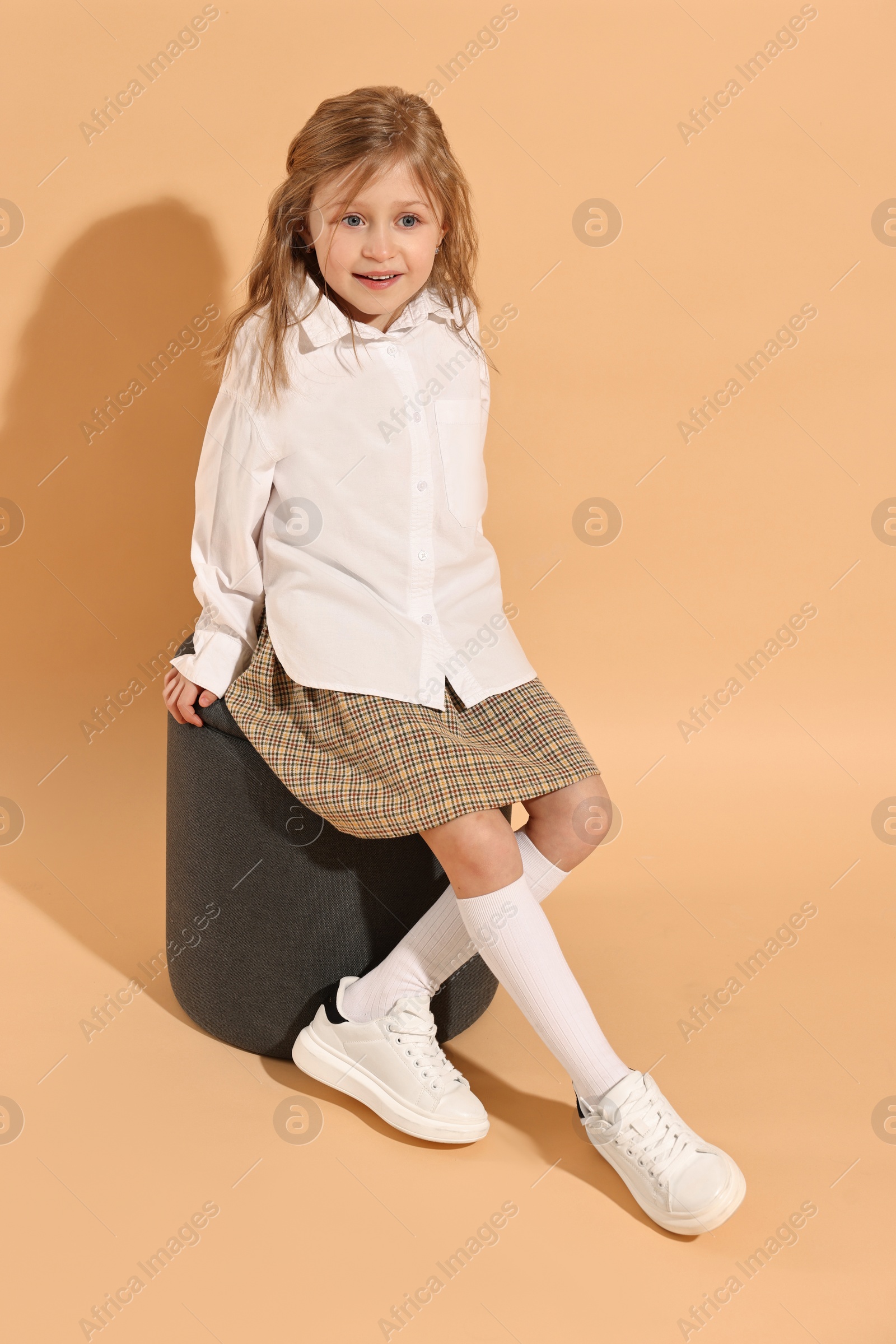 Photo of Fashion concept. Stylish girl on pale orange background