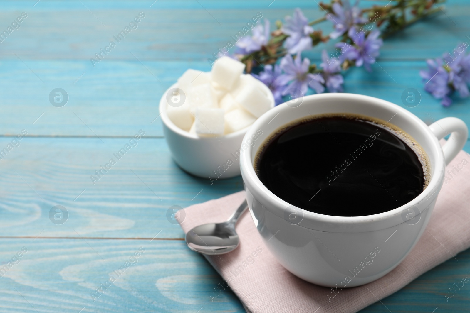 Photo of Cup of delicious chicory drink on turquoise wooden table, space for text