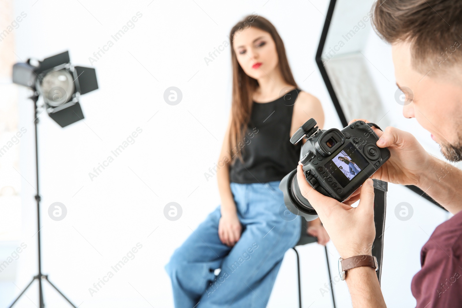 Photo of Beautiful young model posing for professional photographer in studio