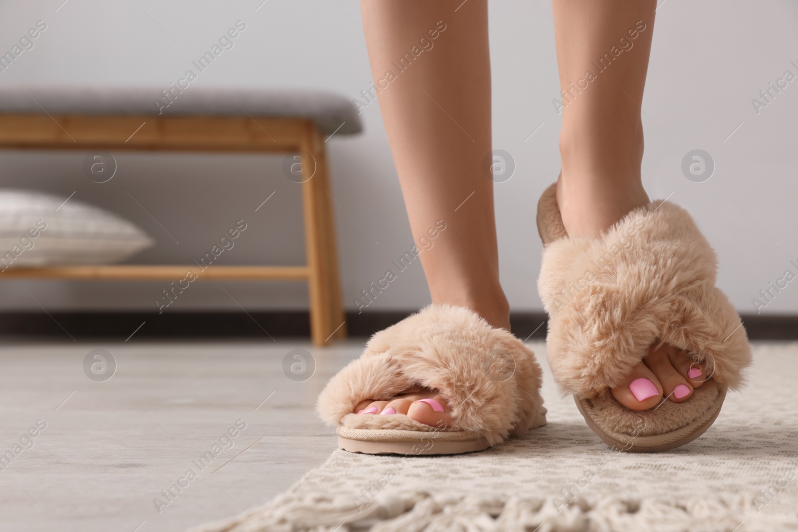 Photo of Woman wearing beige soft slippers indoors, closeup. Space for text