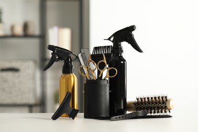 Photo of Set of hairdresser tools on table in salon