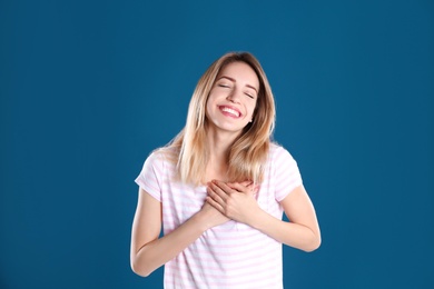 Photo of Portrait of woman holding hands near heart on color background