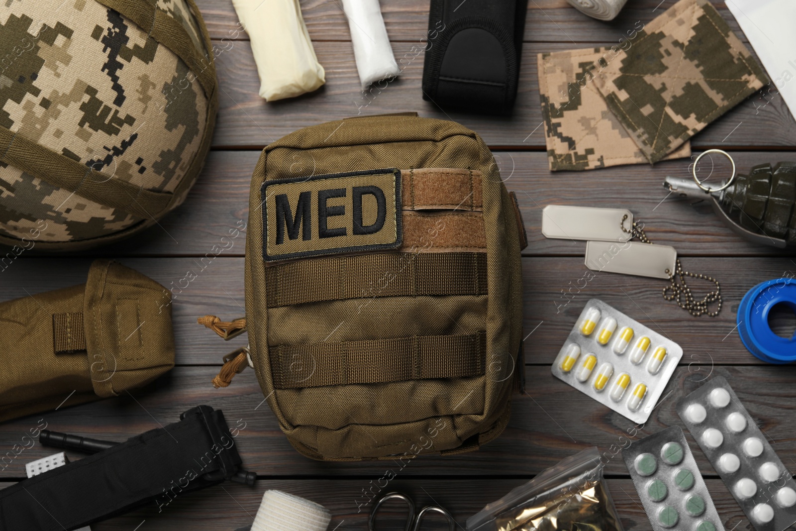 Photo of Military first aid kit on wooden table, flat lay