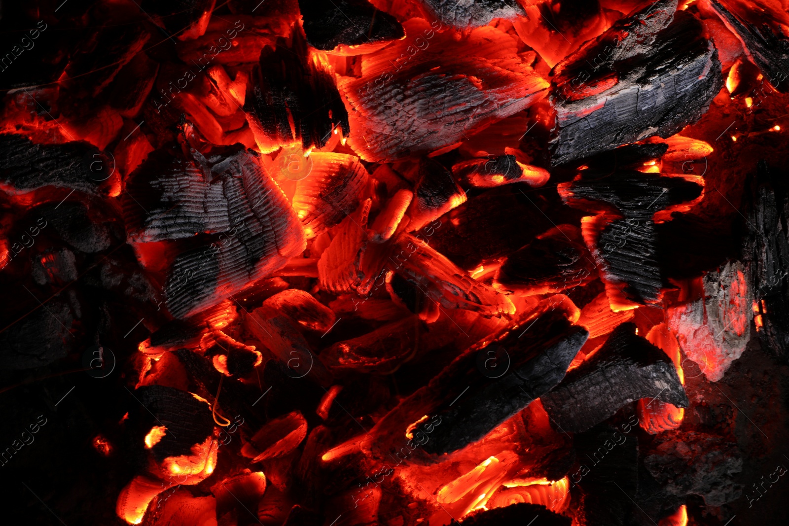 Photo of Pieces of hot smoldering coal as background, top view