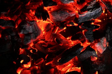 Photo of Pieces of hot smoldering coal as background, top view