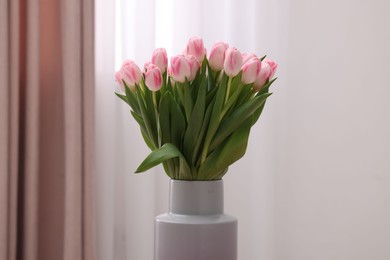 Beautiful bouquet of fresh pink tulips indoors