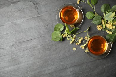 Flat lay composition with tasty tea and linden blossom on black table. Space for text