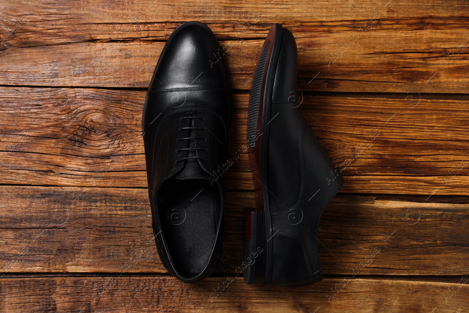 Photo of Pair of black leather men shoes on wooden background, top view