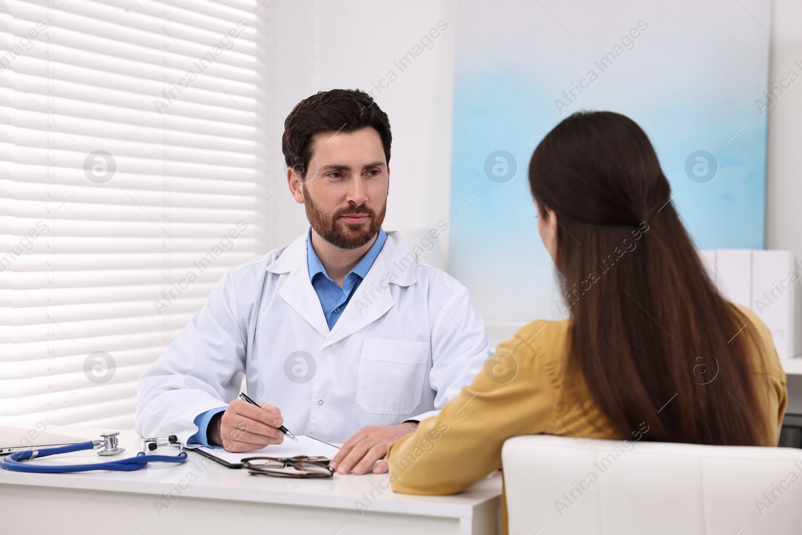 Photo of Doctor consulting patient during appointment in clinic