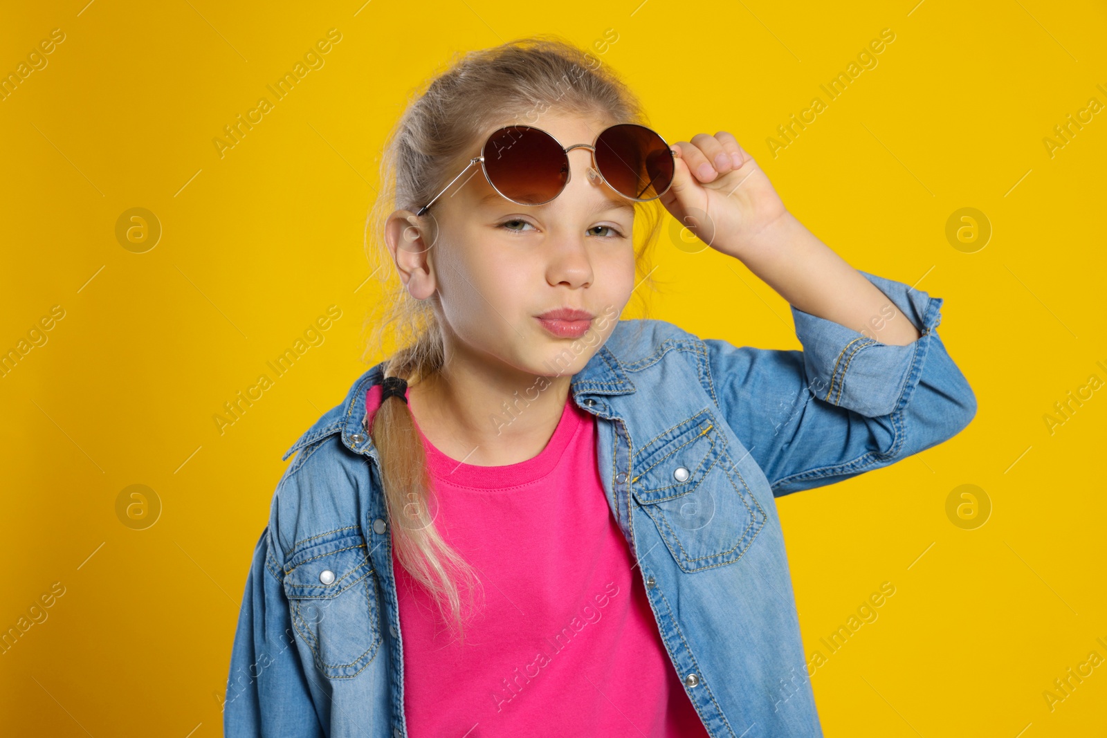 Photo of Girl wearing stylish sunglasses on orange background