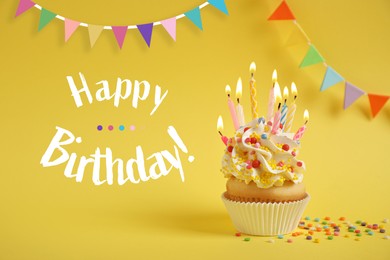 Image of Happy Birthday! Delicious cupcake with candles on yellow background