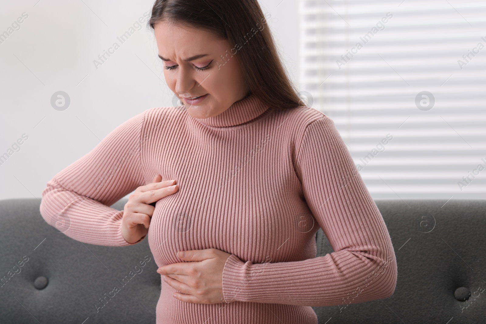 Photo of Mammology. Woman doing breast self-examination at home