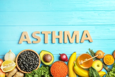 Flat lay composition with natural products as home remedies and word ASTHMA on wooden background