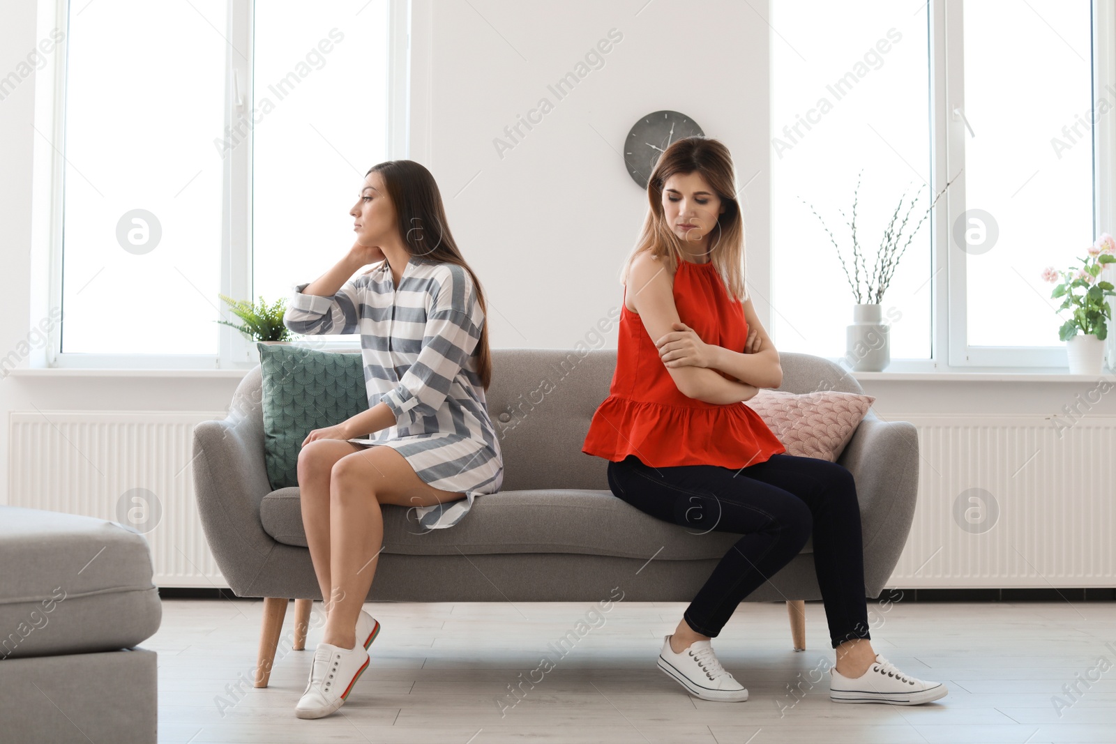 Photo of Women sitting on sofa after arguing at home