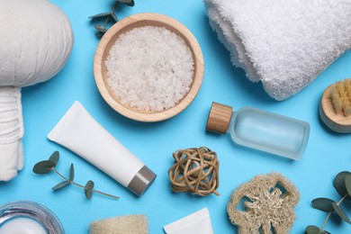 Photo of Flat lay composition with spa products and eucalyptus branches on light blue background