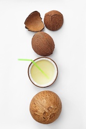 Composition with drink in half of coconut on white background, top view