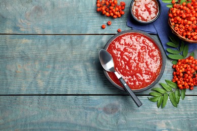 Photo of Flat lay composition with delicious rowan jam on light blue wooden table. Space for text