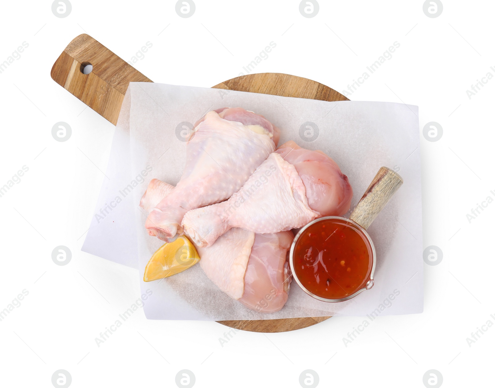 Photo of Fresh marinade, raw chicken drumsticks and lemon wedge isolated on white, top view