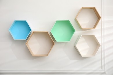 Photo of Empty honeycomb shaped shelves on white wall