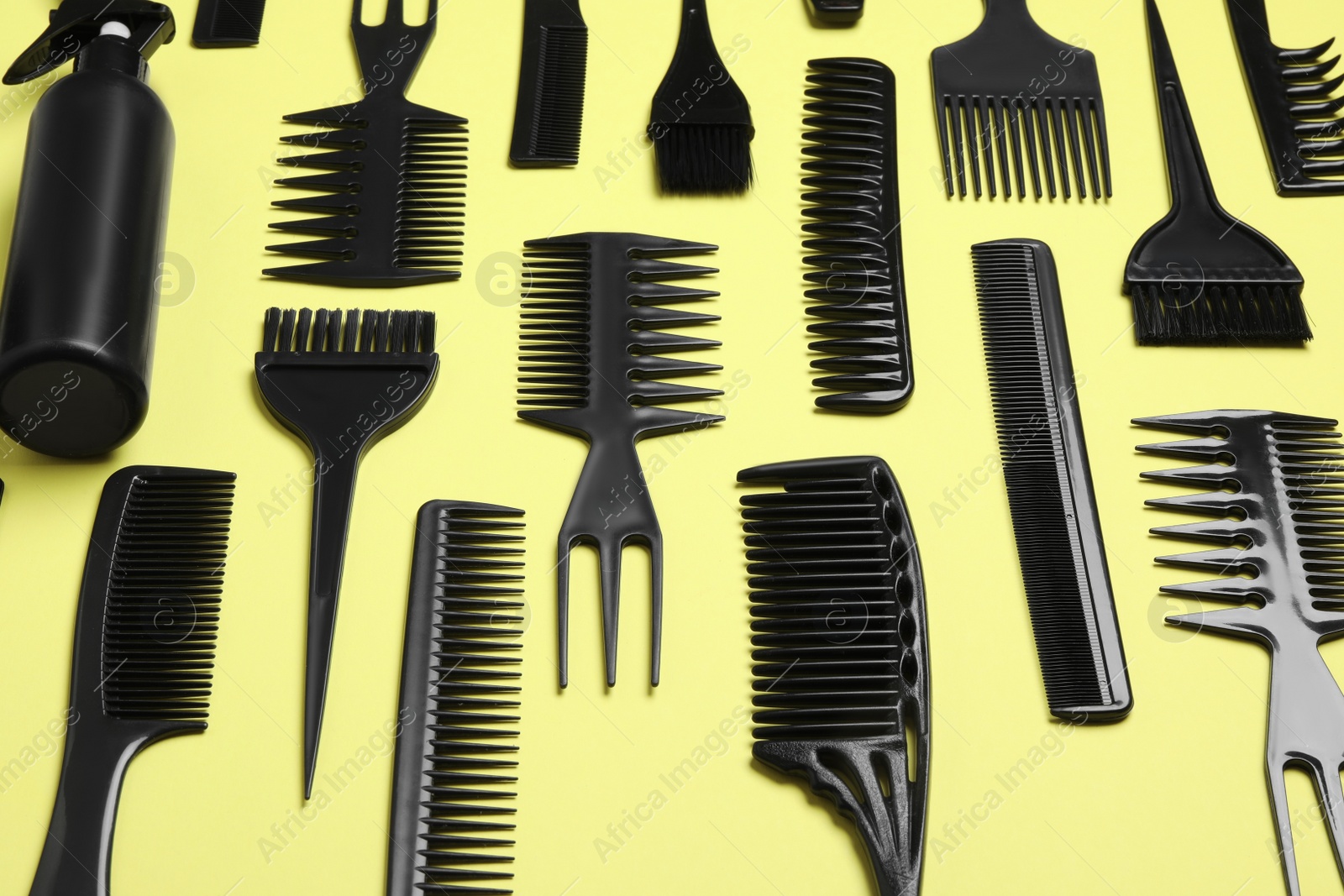 Photo of Composition with modern hair combs on yellow background, above view