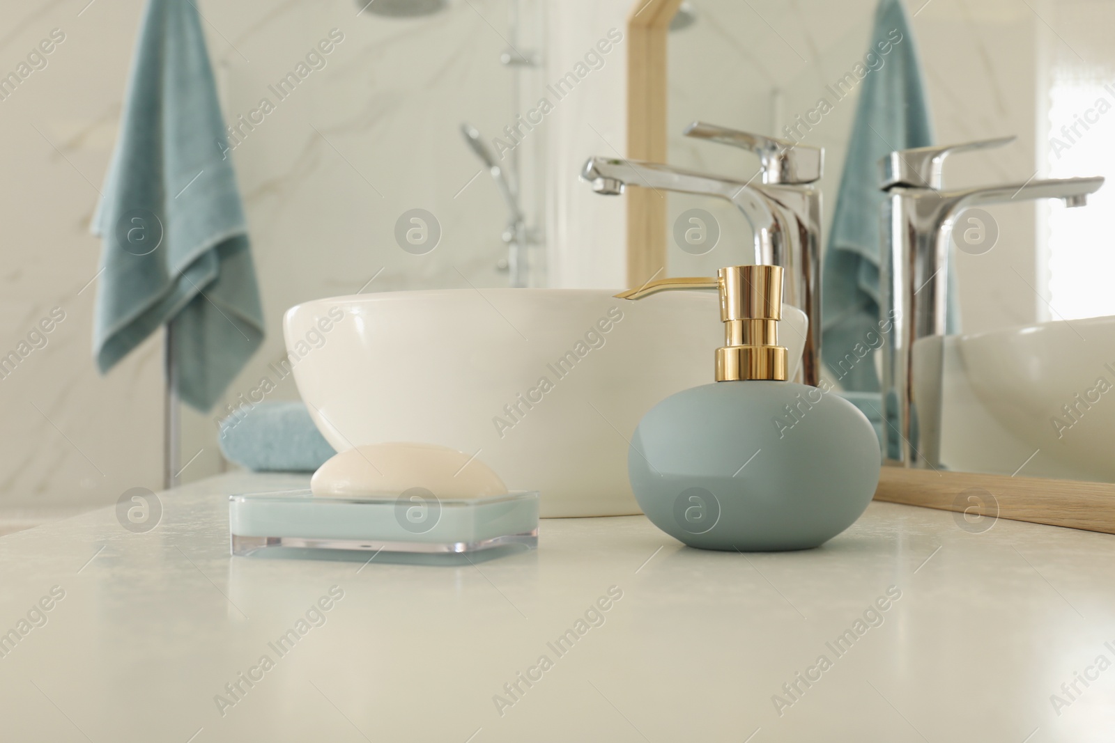 Photo of Toiletries and sink near mirror on white countertop