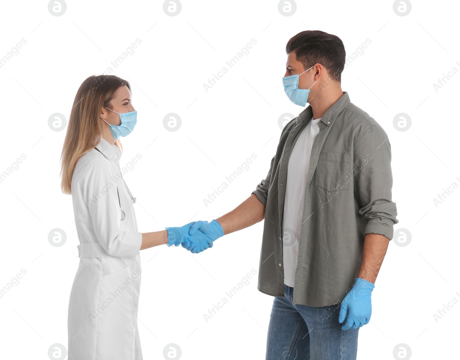 Photo of Doctor and patient in protective masks shaking hands on white background