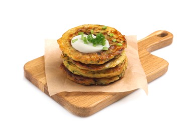 Photo of Delicious zucchini fritters with sour cream on white background