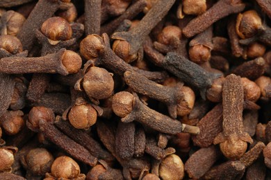 Photo of Aromatic dry cloves as background, closeup view