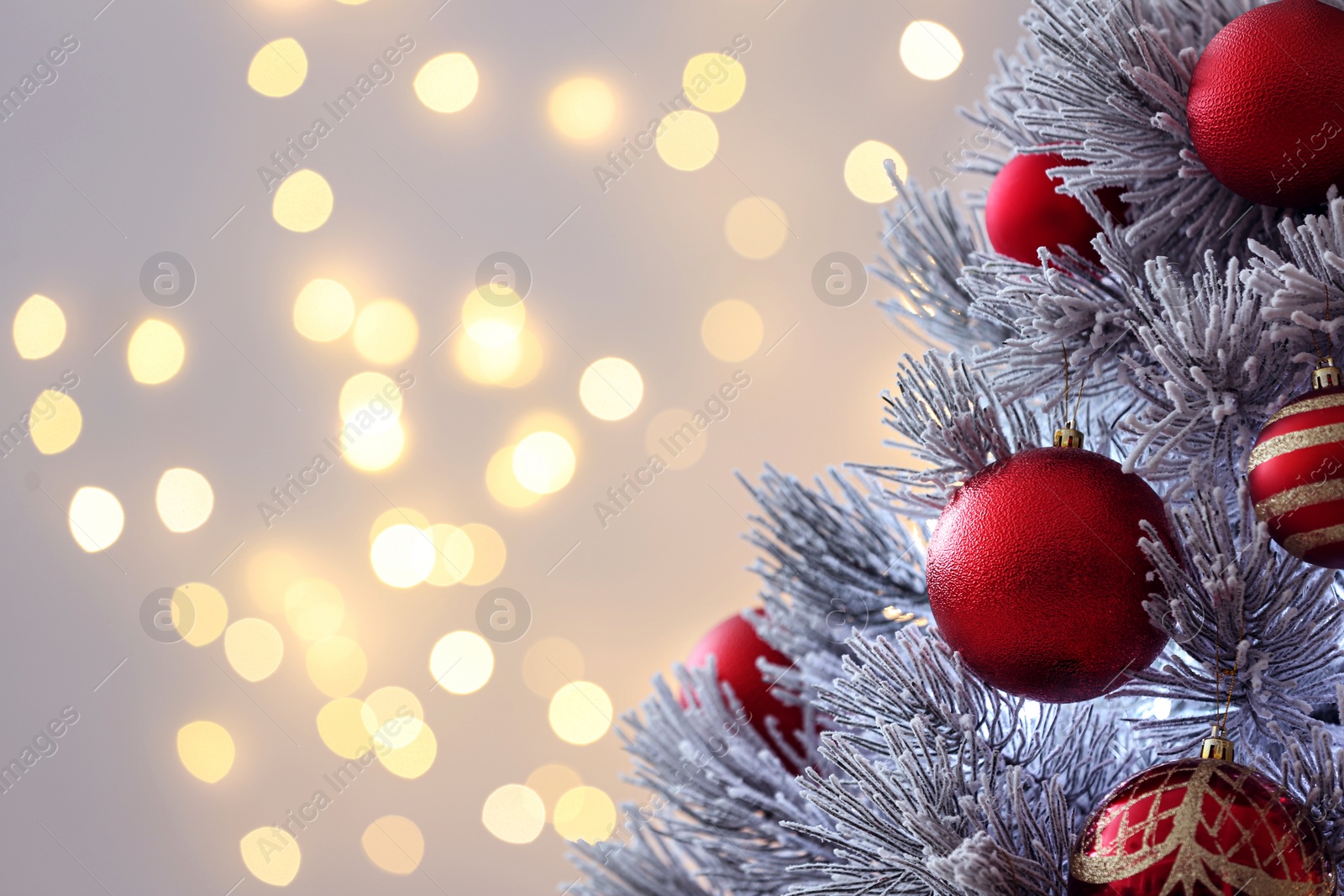 Photo of Decorated Christmas tree against blurred lights on background, space for text. Bokeh effect