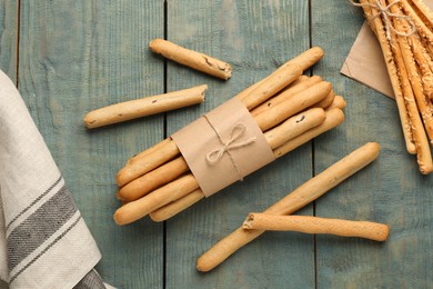 Delicious grissini sticks on wooden table, flat lay