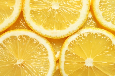 Photo of Juicy lemon slices as background, top view. Citrus fruit