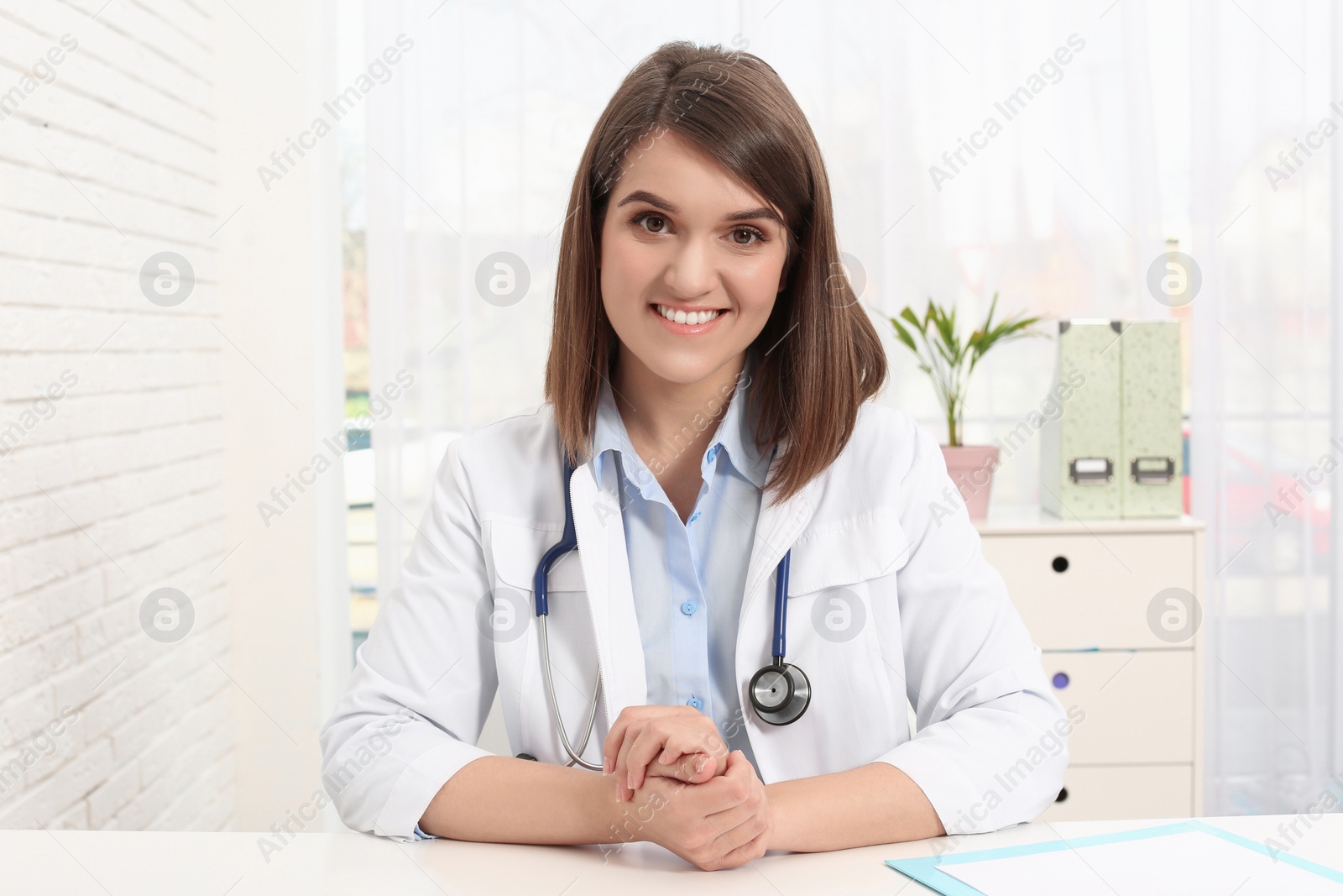 Photo of Portrait of pediatrician at table in clinic