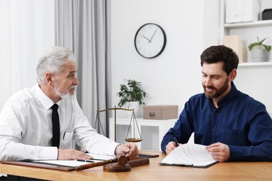 Man signing document at table in lawyer's office