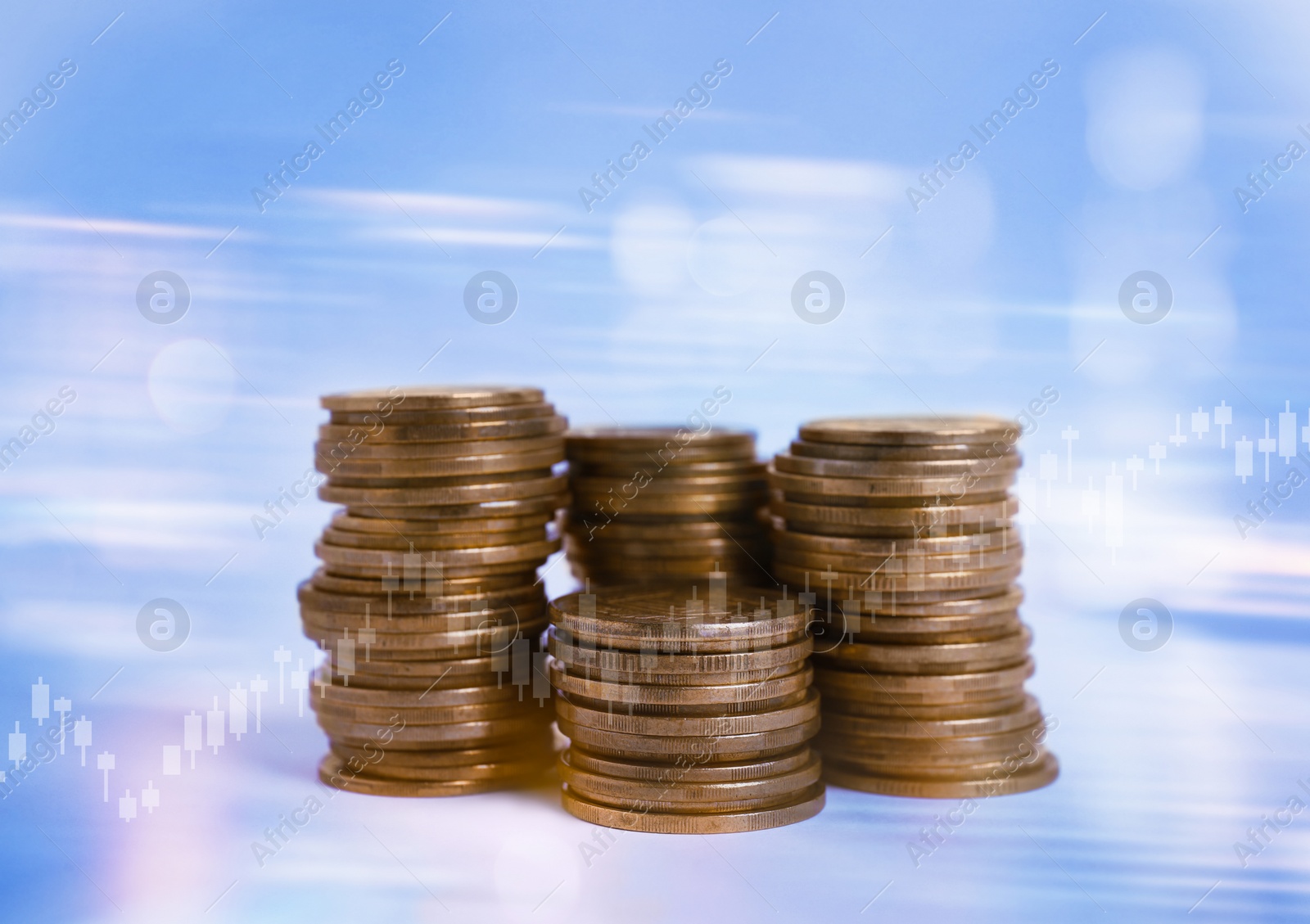 Image of Stacked coins and charts on light blue background