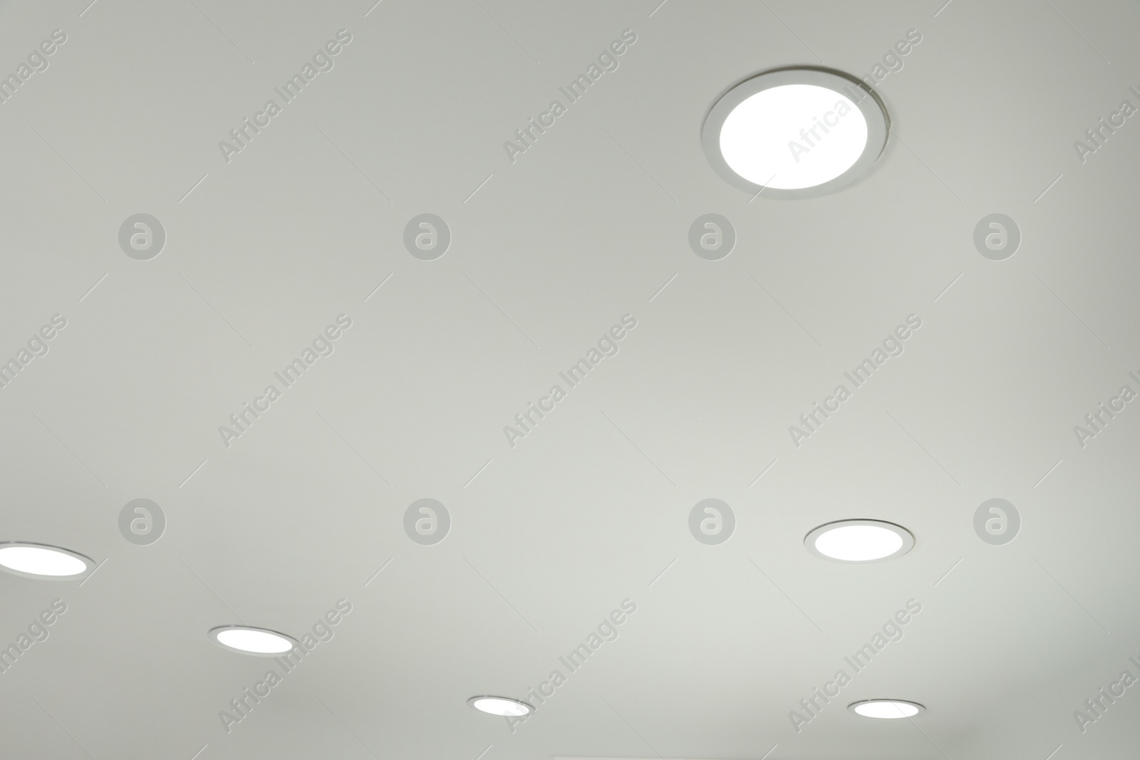 Photo of White ceiling with lamps indoors, below view