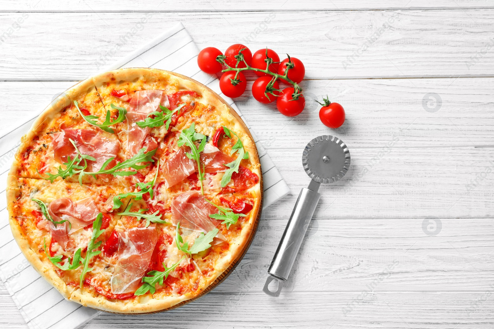 Photo of Tasty hot pizza, cherry tomatoes and knife on wooden background, top view