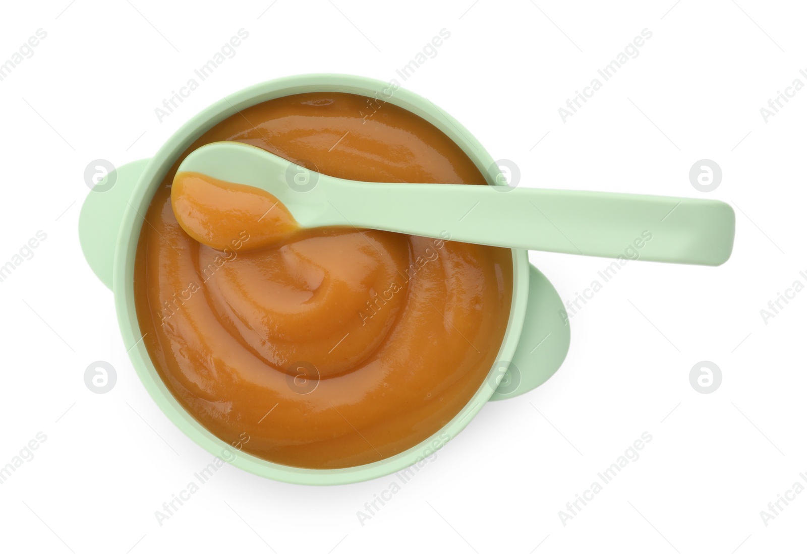 Photo of Bowl and spoon with tasty pureed baby food isolated on white, top view