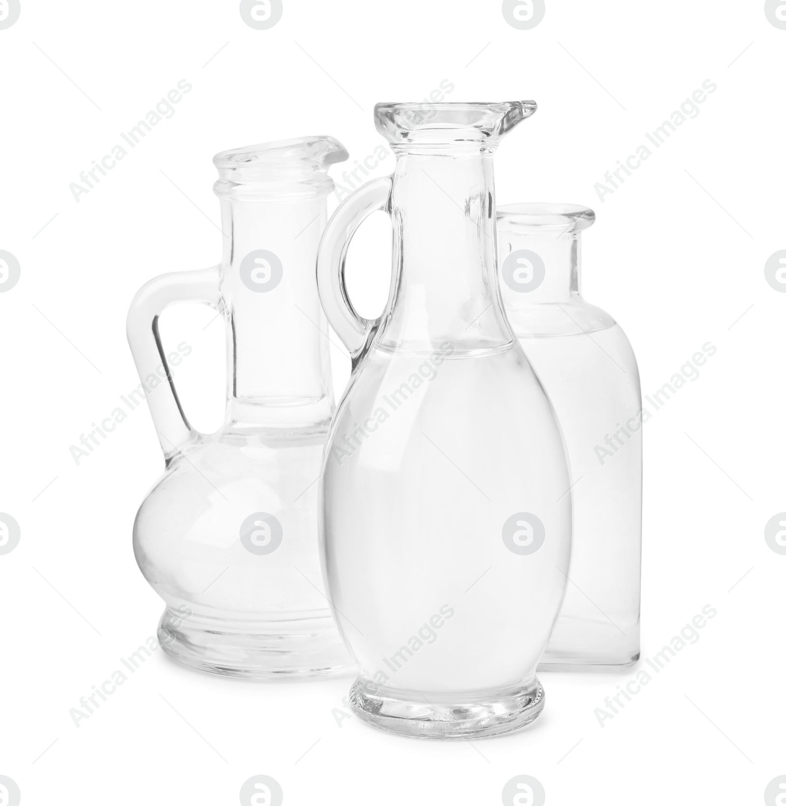 Photo of Vinegar in glass jugs and bottle isolated on white