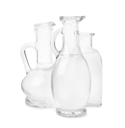 Photo of Vinegar in glass jugs and bottle isolated on white