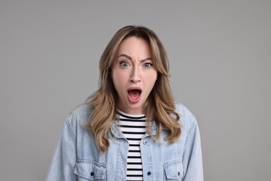 Photo of Portrait of surprised woman on grey background